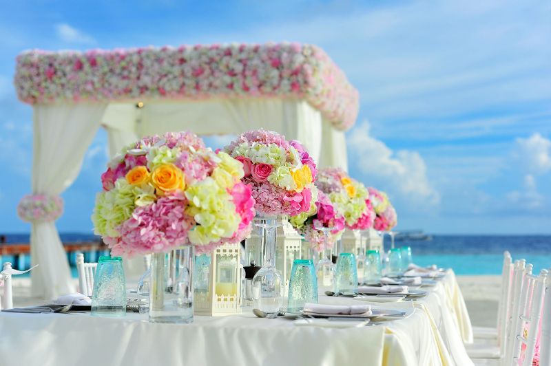 a beautiful wedding venue with many flowers near the beach